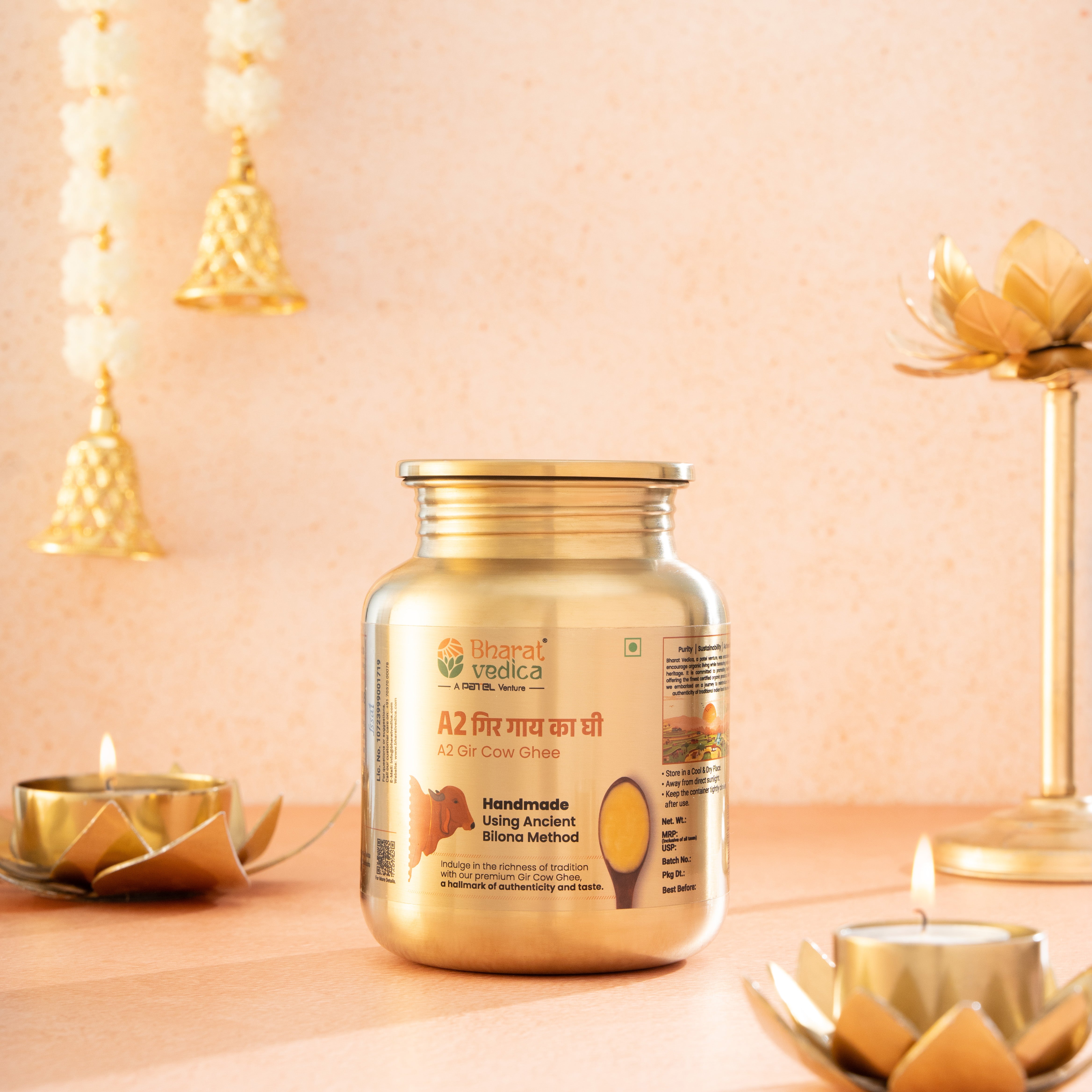 Bharat Vedica A2 Gir Cow Ghee in Stainless Steel Jar on a decorative background with candles and lights