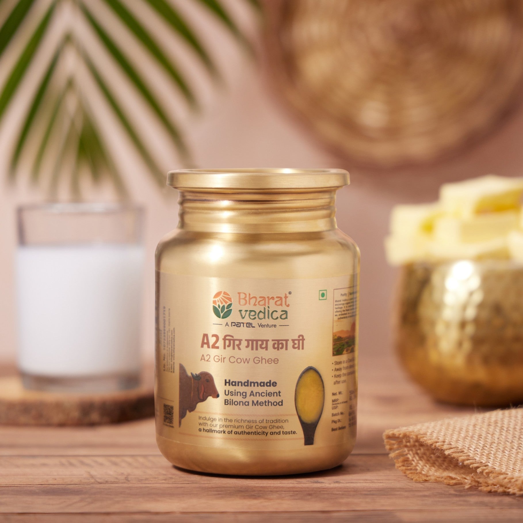 Bharat Vedica A2 Gir Cow Ghee in a stainless steel jar on a wooden surface with a blurred background