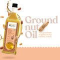 Bottle of Bharat Vedica Organic Wood Pressed Groundnut Oil with peanuts and oil splashes on a beige background