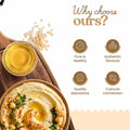 Hummus on a wooden board with oil, sesame seeds, and why choose Bharat Vedica Organic Wood Pressed White Sesame Oil