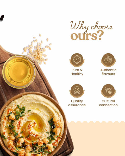 Hummus on a wooden board with oil, sesame seeds, and why choose Bharat Vedica Organic Wood Pressed White Sesame Oil